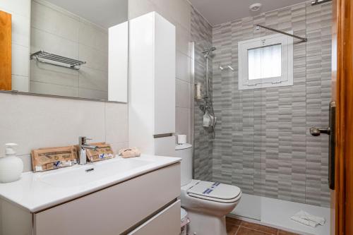 ein Badezimmer mit Toilette, Waschbecken und Dusche in der Unterkunft Jardín del Golf apartamento con jardín privado in Chiclana de la Frontera