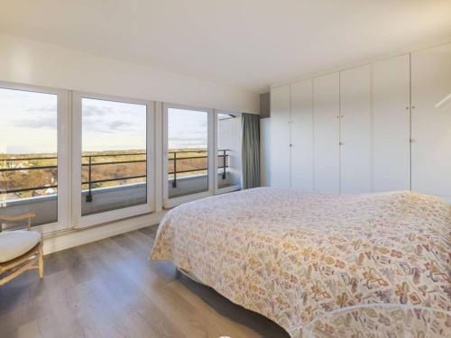 une chambre avec un lit et de grandes fenêtres dans l'établissement Magnifique appartement au Touquet, balcon vue mer, wifi, box inclus - FR-1-821-1, à Le Touquet-Paris-Plage