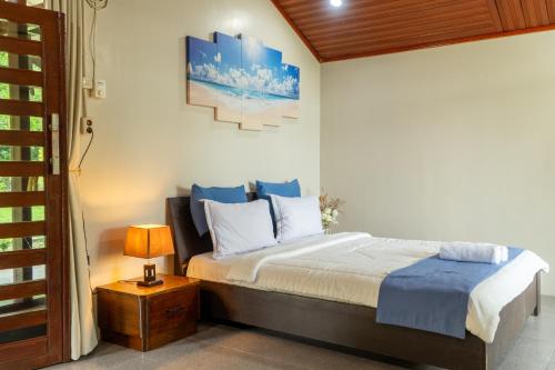 a bedroom with a bed and a lamp on a table at The Hawk's Nest Resort in Sabong