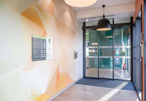 an entrance to a building with a colorful wall at B&B HOTEL Bordeaux Bassins à flot in Bordeaux
