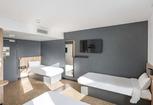 a hospital room with two beds and a tv at B&B HOTEL Bordeaux Bassins à flot in Bordeaux