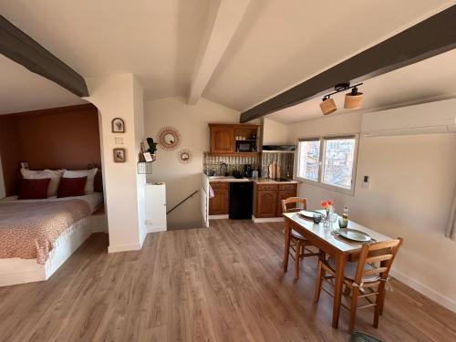 une chambre avec un lit et une table et une cuisine dans l'établissement L'Origan, Studio sous les toits, à Draguignan