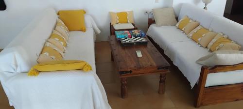 a living room with two white couches and a table at EMPHASIS Traditional House in Apodhoúlou