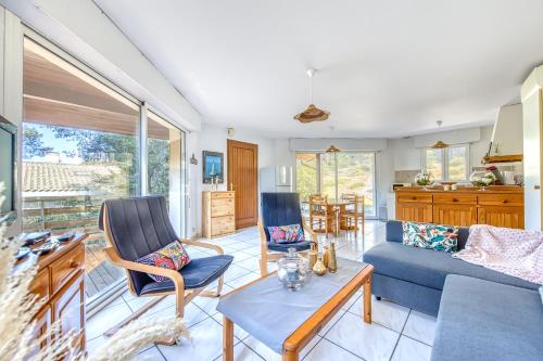 un salon avec un canapé bleu et des chaises dans l'établissement La Pinède - Carcans, Medoc, à Carcans