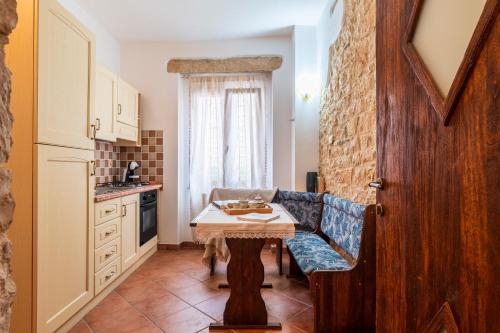 a kitchen with a table in the middle of a room at Su Cilleri e Silbiu in Baunei