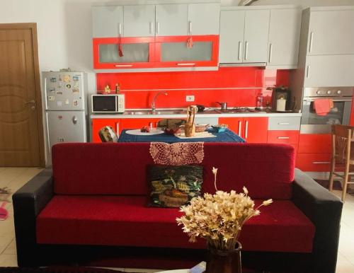 ein Wohnzimmer mit einer roten Couch in einer Küche in der Unterkunft Pippa in Korçë