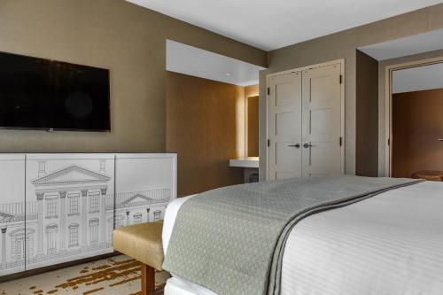 a bedroom with a bed and a flat screen tv at Omni Louisville Hotel in Louisville
