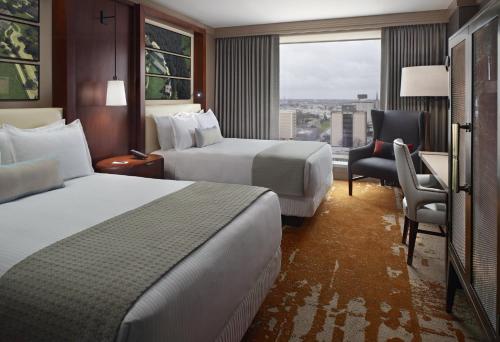 a hotel room with two beds and a chair at Omni Louisville Hotel in Louisville