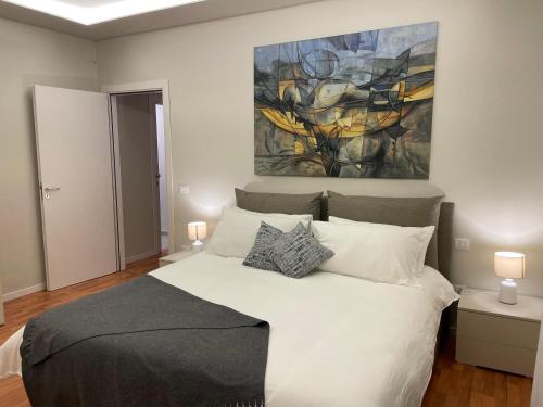 a bedroom with a bed with a painting on the wall at Magellano Home in San Gregorio di Catania