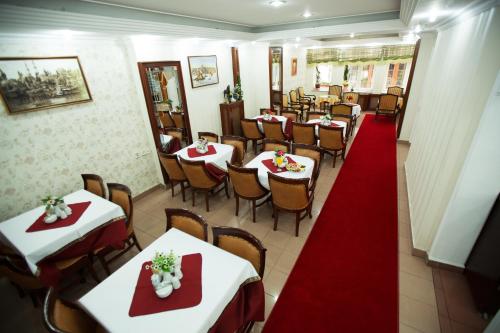 a restaurant with white tables and chairs with red napkins at Sirkeci Emek Hotel in Istanbul