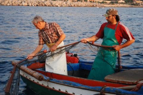 two men in a small boat in the water at Case Vacanze Terra Sinus in Terrasini