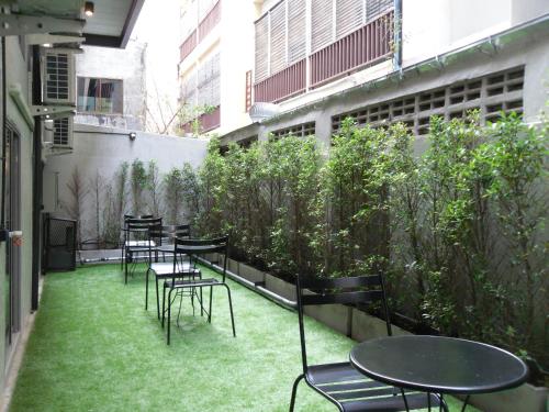 a row of tables and chairs on a patio with grass at Sea Crest by Jomtien in Jomtien Beach