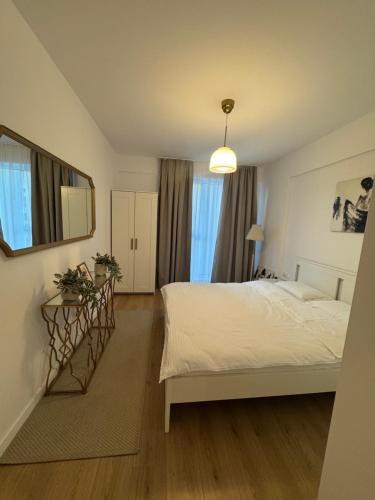 a bedroom with a white bed and a window at ABE Apartment in Craiova