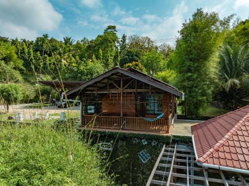 a cabin in the middle of a garden with trees at The Hawk's Nest Resort in Sabong