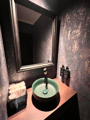 a bathroom with a sink and a mirror and towels at Hotel Cocó in Timişoara