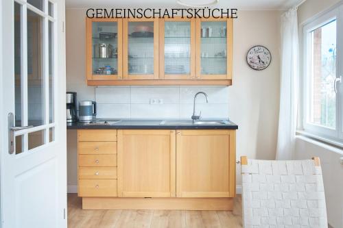 a kitchen with wooden cabinets and a sink at Villa Dünenblick Doppelzimmer Leuchtturm in Timmendorfer Strand