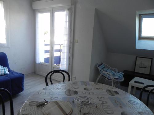 un salon avec une table et une fenêtre dans l'établissement Duplex à 150m de la mer, à Concarneau