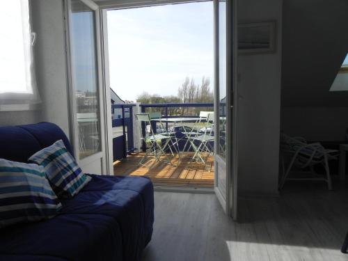 un salon avec un canapé et une porte coulissante en verre dans l'établissement Duplex à 150m de la mer, à Concarneau