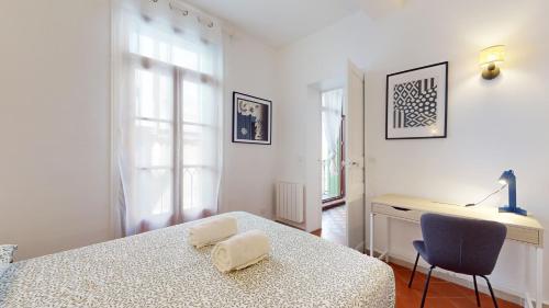 une chambre avec un lit, un bureau et une chaise dans l'établissement Le Perpignan Chic, à Perpignan