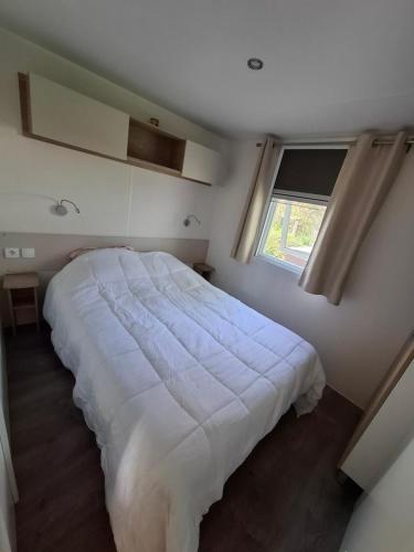 une chambre avec un grand lit blanc avec une fenêtre dans l'établissement Le lac des reves, à Lattes