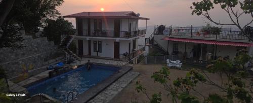 ShogiVatika Resorts Cottages的一栋前面有游泳池的房子