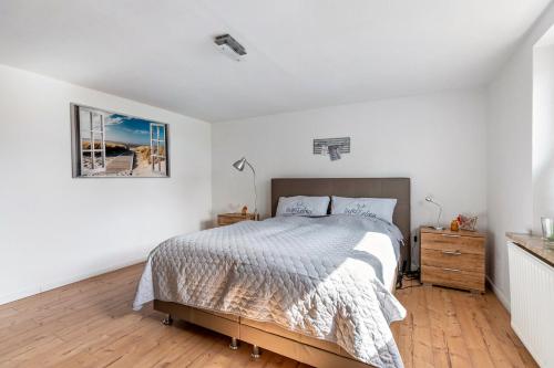 a bedroom with a bed and a picture on the wall at Ferienhaus Angela in Neuenkirchen