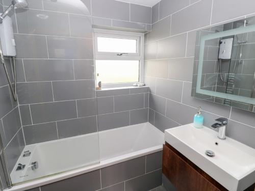 a bathroom with a tub and a sink and a shower at Carreg Yr Onnen in Haverfordwest
