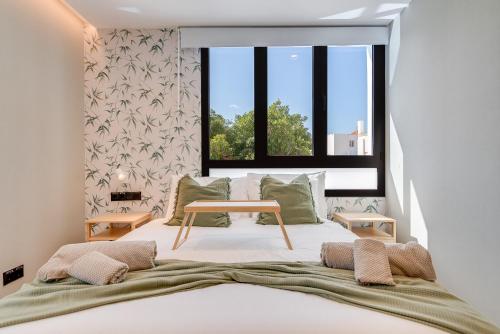 a bedroom with a large bed with a window at Las Dunas de Santa Catalina Boutique House in Las Palmas de Gran Canaria