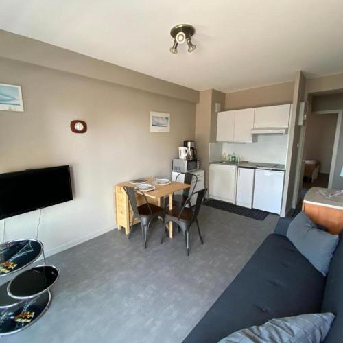 un salon avec une table et une cuisine dans l'établissement L'arbre du voyageur, à Les Sables-dʼOlonne