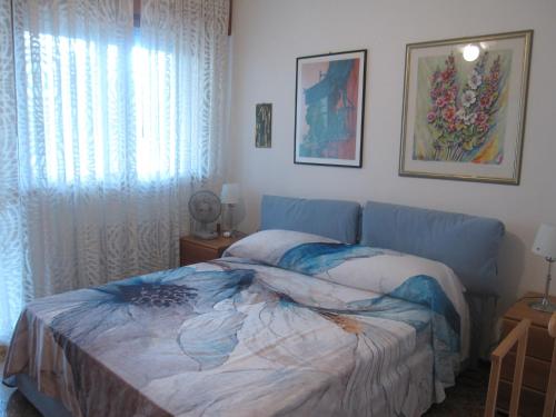 a bedroom with a blue bed and a window at Appartamento Aquileia in Lido