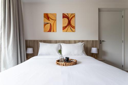 a bedroom with a white bed with a tray on it at Hub Boa Vista by Viva - Prédio novo próximo ao Autódromo de Interlagos com lavanderia e academia in Sao Paulo