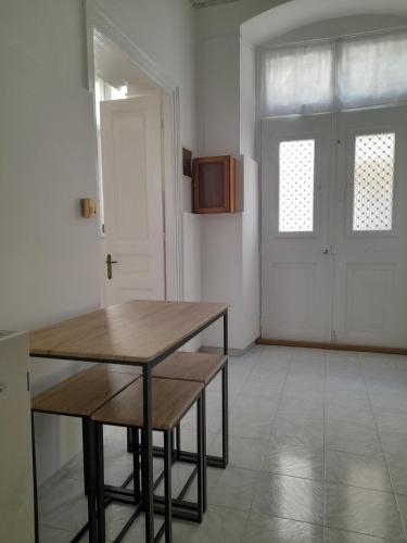 a dining room with a wooden table and a door at Marielli's house in Ermoupoli