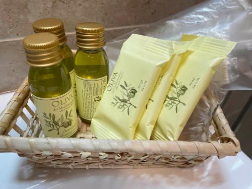 a basket with three bottles of oils in a refrigerator at Hotel Clementi in Salice Terme