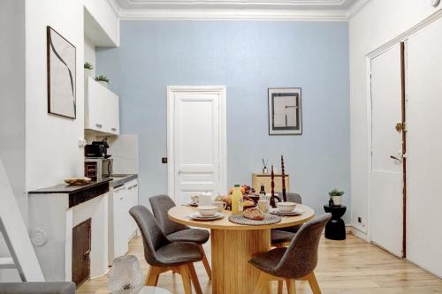 une salle à manger avec une table et des chaises dans une cuisine dans l'établissement Charme Parisien Studio Cosy pour 4 Personnes, à Paris