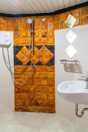 a bathroom with a sink and a brick wall at The Hawk's Nest Resort in Sabong