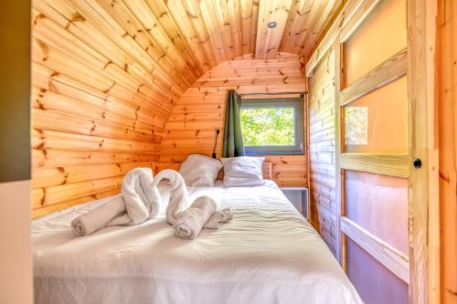 Un dormitorio con una cama en una cabaña de madera. en Otonneauxstress - Vigneron, en Saint-Vivien-de-Médoc