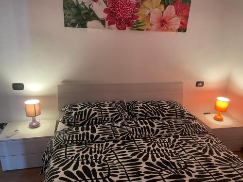 a bedroom with a black and white bed and two lamps at Casa Unzaja22 in Savona