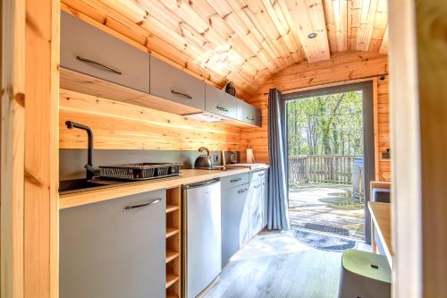 - une cuisine dans une petite maison avec une grande fenêtre dans l'établissement Ôtonneauxstress - Vigneron, à Saint-Vivien-de-Médoc