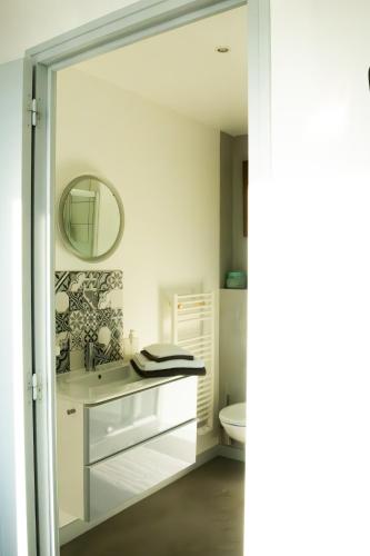 une salle de bain blanche avec un lavabo et des toilettes dans l'établissement Villa Bel-Amy, à Saint-Pair-sur-Mer