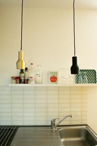 - une cuisine avec deux lampes suspendues au-dessus d'un évier dans l'établissement Villa Bel-Amy, à Saint-Pair-sur-Mer