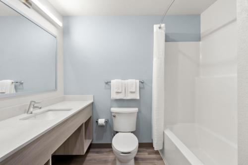 a bathroom with a toilet and a sink and a shower at WoodSpring Suites Chandler Phoenix Medical Center in Chandler