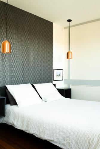 - une chambre avec un lit blanc et deux lampes dans l'établissement Villa Bel-Amy, à Saint-Pair-sur-Mer