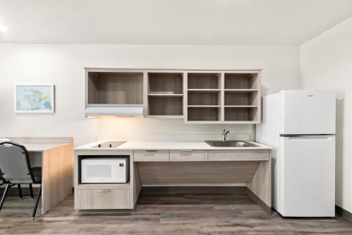 a kitchen with a sink and a refrigerator at WoodSpring Suites Chandler Phoenix Medical Center in Chandler