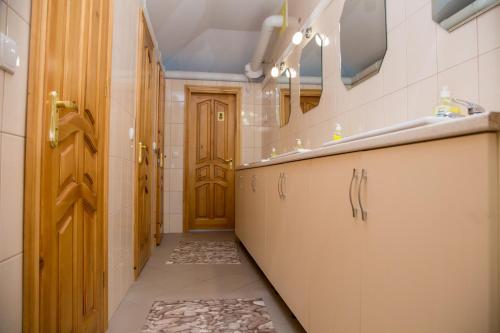 a hallway of a bathroom with a door and a sink at Lions Heart Hostel in Lviv