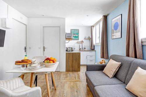 - un salon avec un canapé et une table avec des fruits dans l'établissement Studio Cosy au coeur de Paris pres des Buttes-Chaum, à Paris