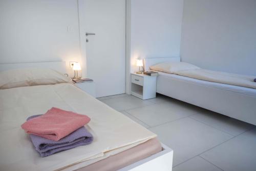 a white bedroom with two beds and two lamps at 4 Bedroom Private House On The Hill in Ljubljana