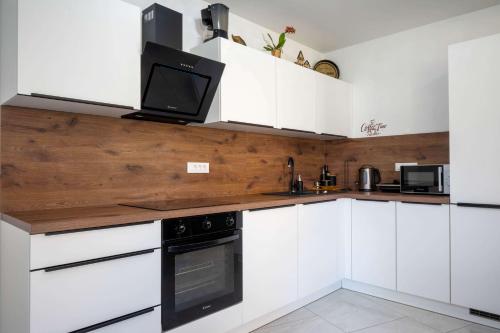 a kitchen with white cabinets and a tv on the counter at 4 Bedroom Private House On The Hill in Ljubljana