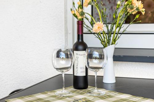 a bottle of wine and two wine glasses on a table at Ferienwohnung Sterl 13 in Herscheid
