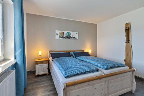 a bedroom with a bed with blue pillows at Ferienwohnung Sterl 13 in Herscheid