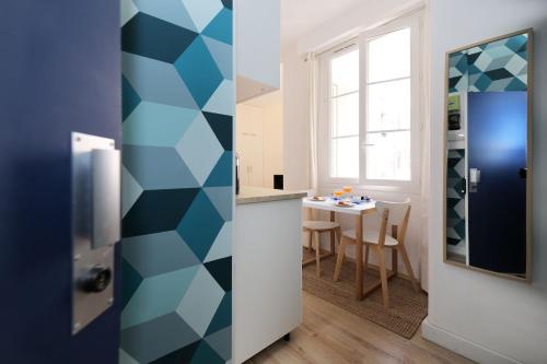 une cuisine avec un mur géométrique bleu et blanc dans l'établissement Studio original et reposant - Paris 10 - 2P, à Paris